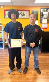 Student receiving Wing Chun certificate from GM Lung